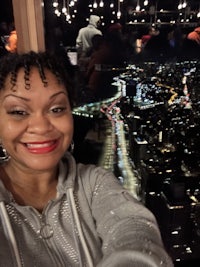a woman is taking a selfie in front of the brooklyn bridge