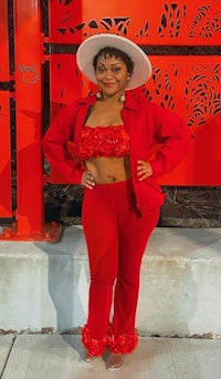 a woman wearing red pants and a white hat