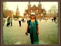 a woman in a blue dress standing in front of kremlin