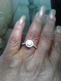 a woman's hand with a diamond ring on it